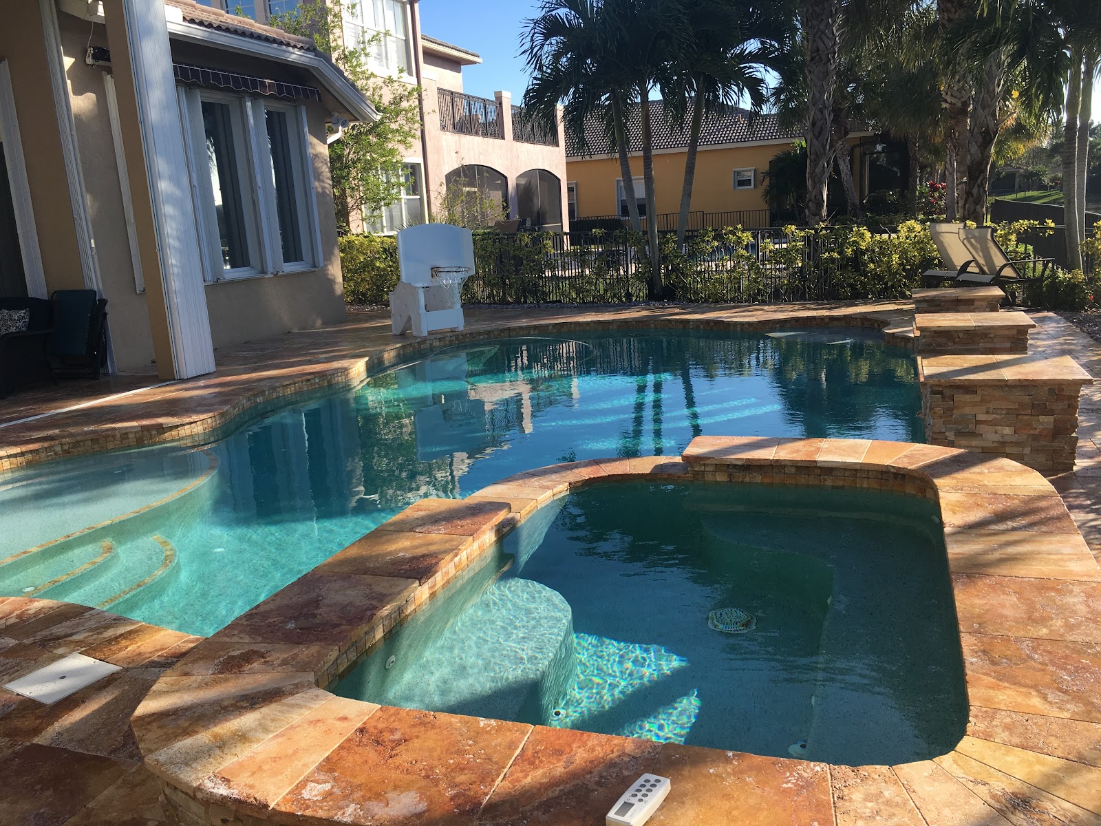 Curved pool with integrated spa and travertine deck