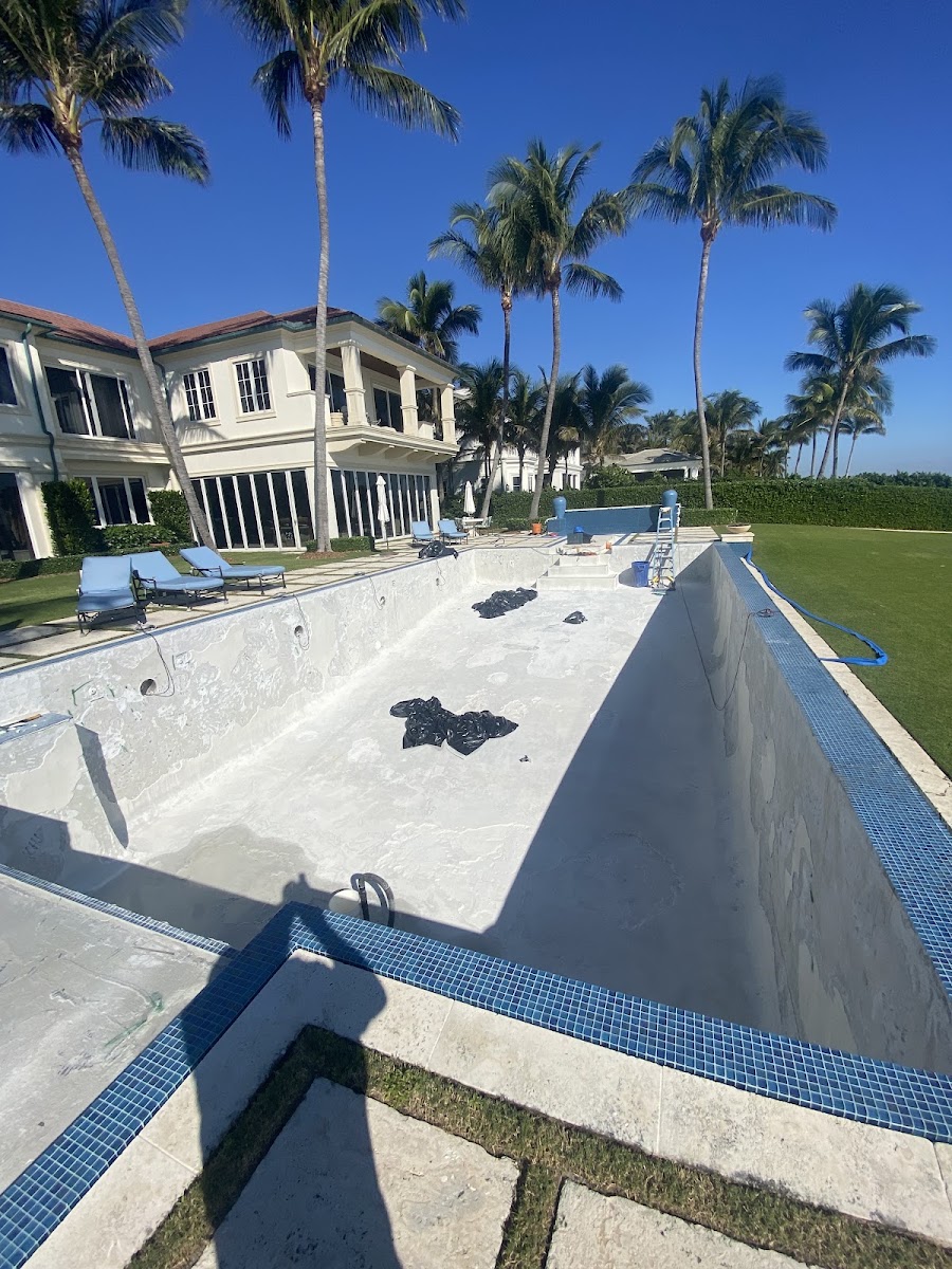 Drained pool mid-renovation with equipment on the deck