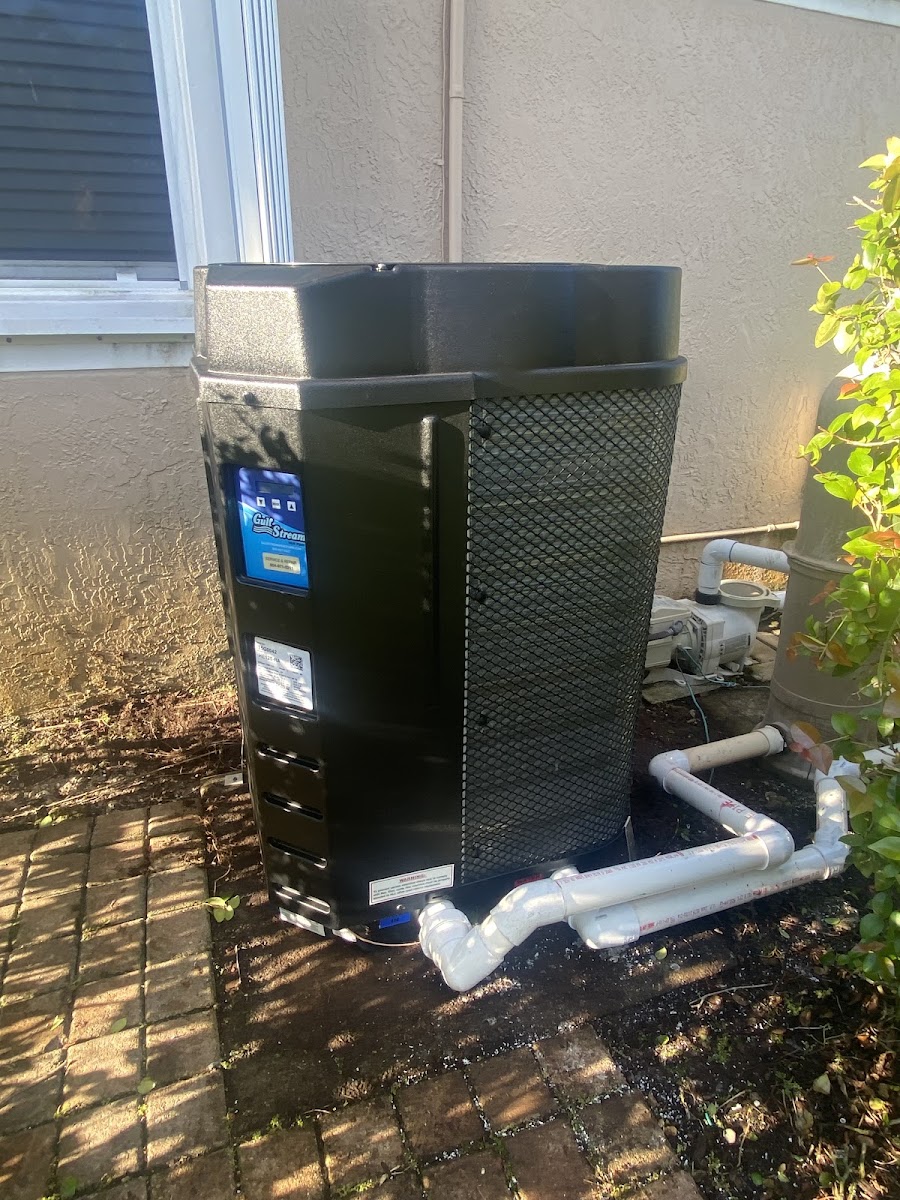 Pool heat pump and plumbing at an equipment pad